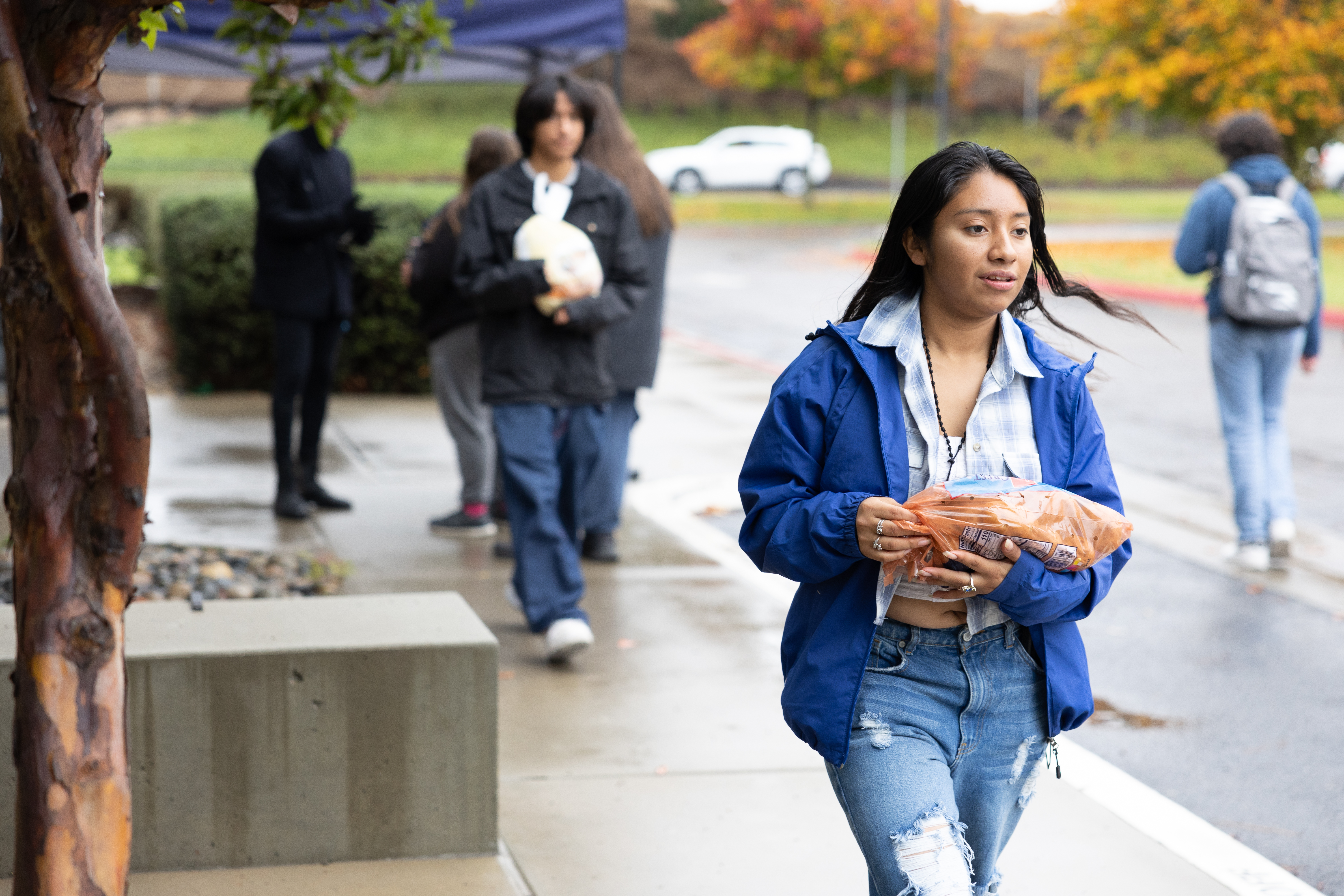 Student handing out turkeys during the EOPS+ 2024 Turkey Fest