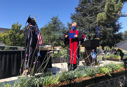 A graduate walking across the stage at commencement.