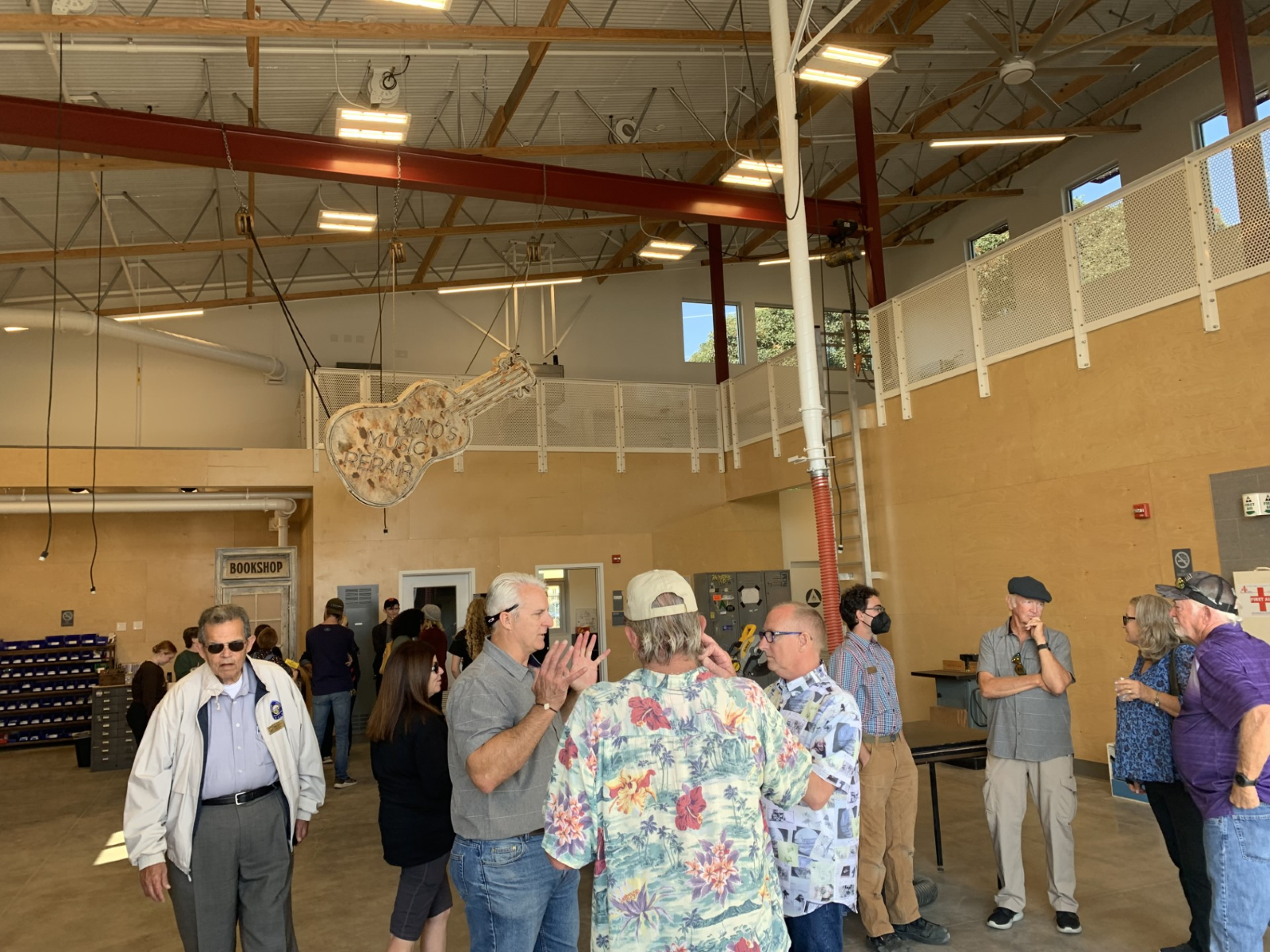 A group of people stand inside a building housing props and costumes for plays. 