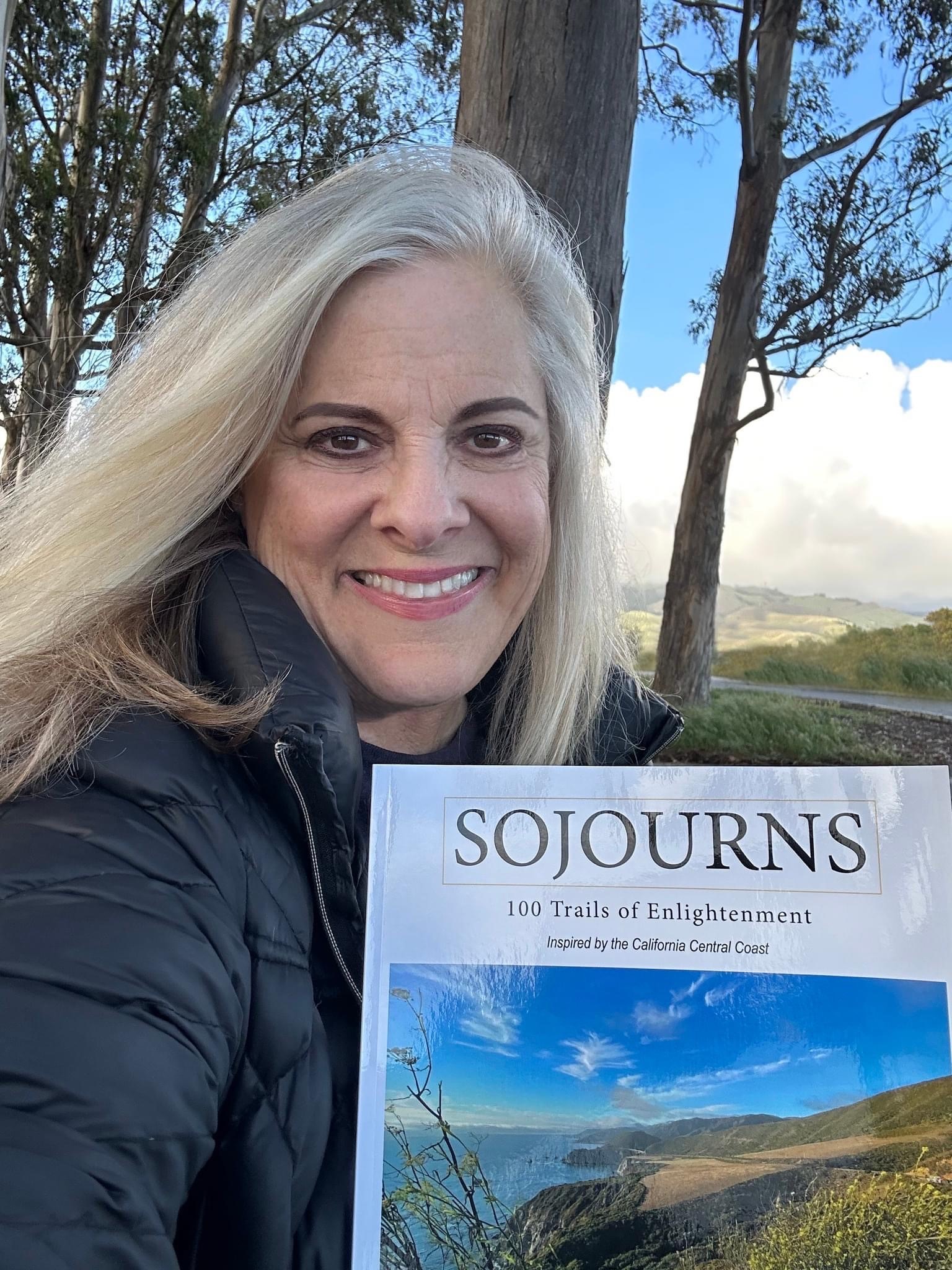 Hancock instructor and author Jill Thayer holds up a copy of her new book. 