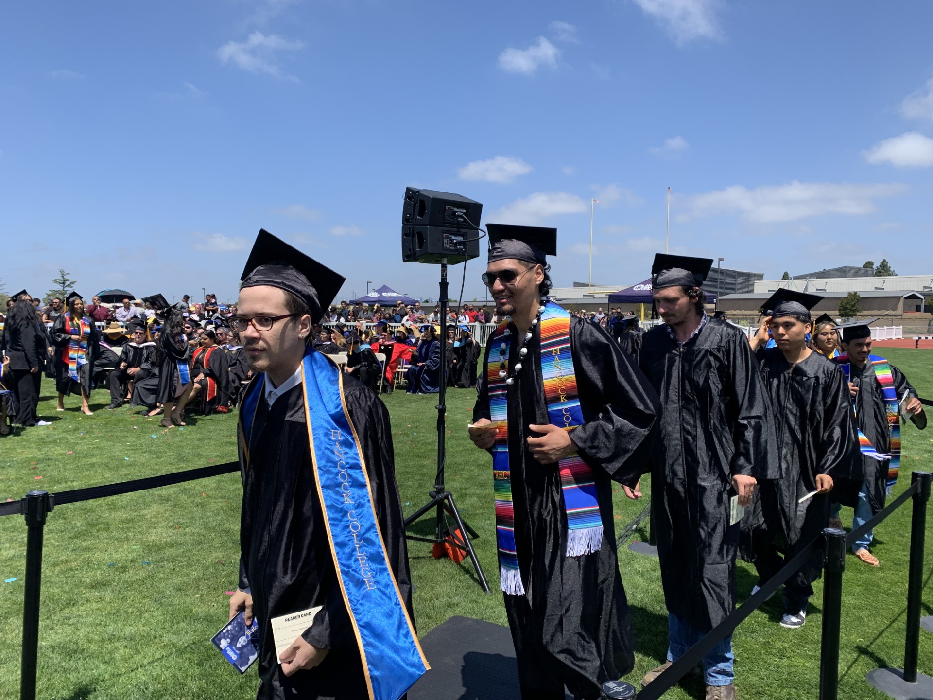 Graduates in caps and gowns wait in line to graduate from Allan Hancock College. 