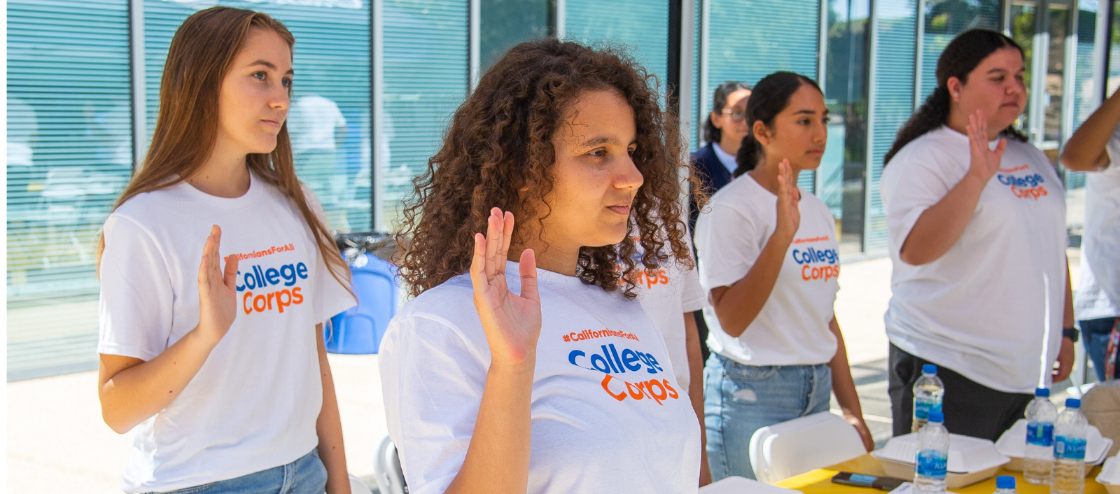 A group of students wearing College Corps shirts swearing oath