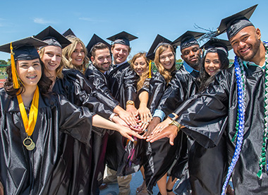 Graduates stacking their hands