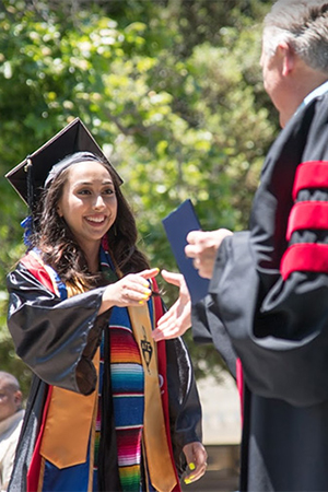 Young woman receiving a college diploma at graduation