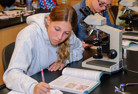 girl sitting at microscope