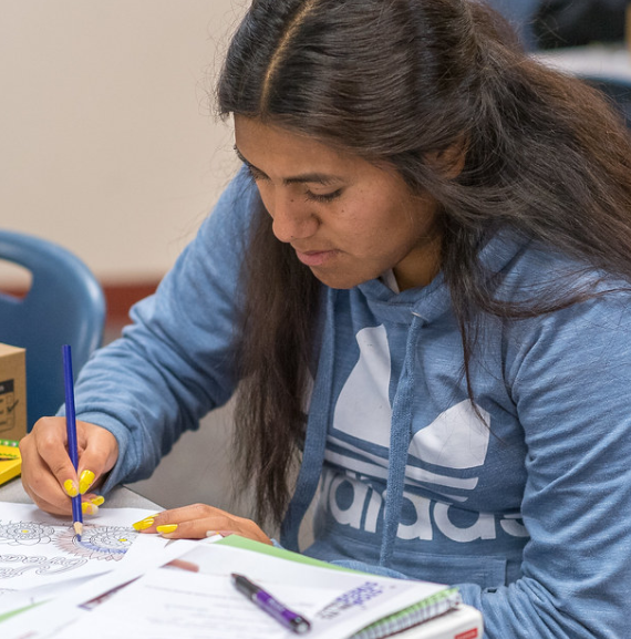 Student coloring in a theraputic sheet
