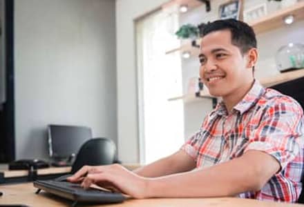 Man sitting at computer smiling