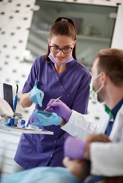 Woman dental assistant talking to dentist