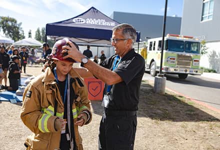 student trying on firefighter gear