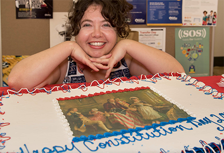 Woman in front of "Constitution Day" cake