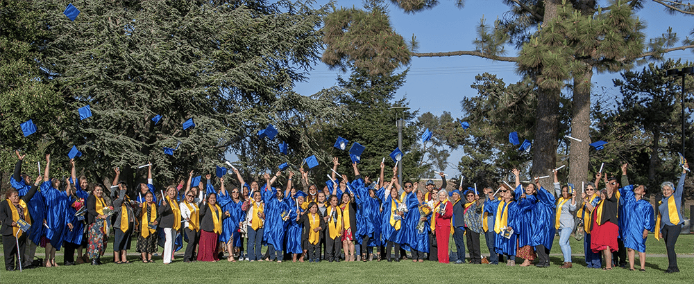 Large group of noncredit students wearing graduation robes